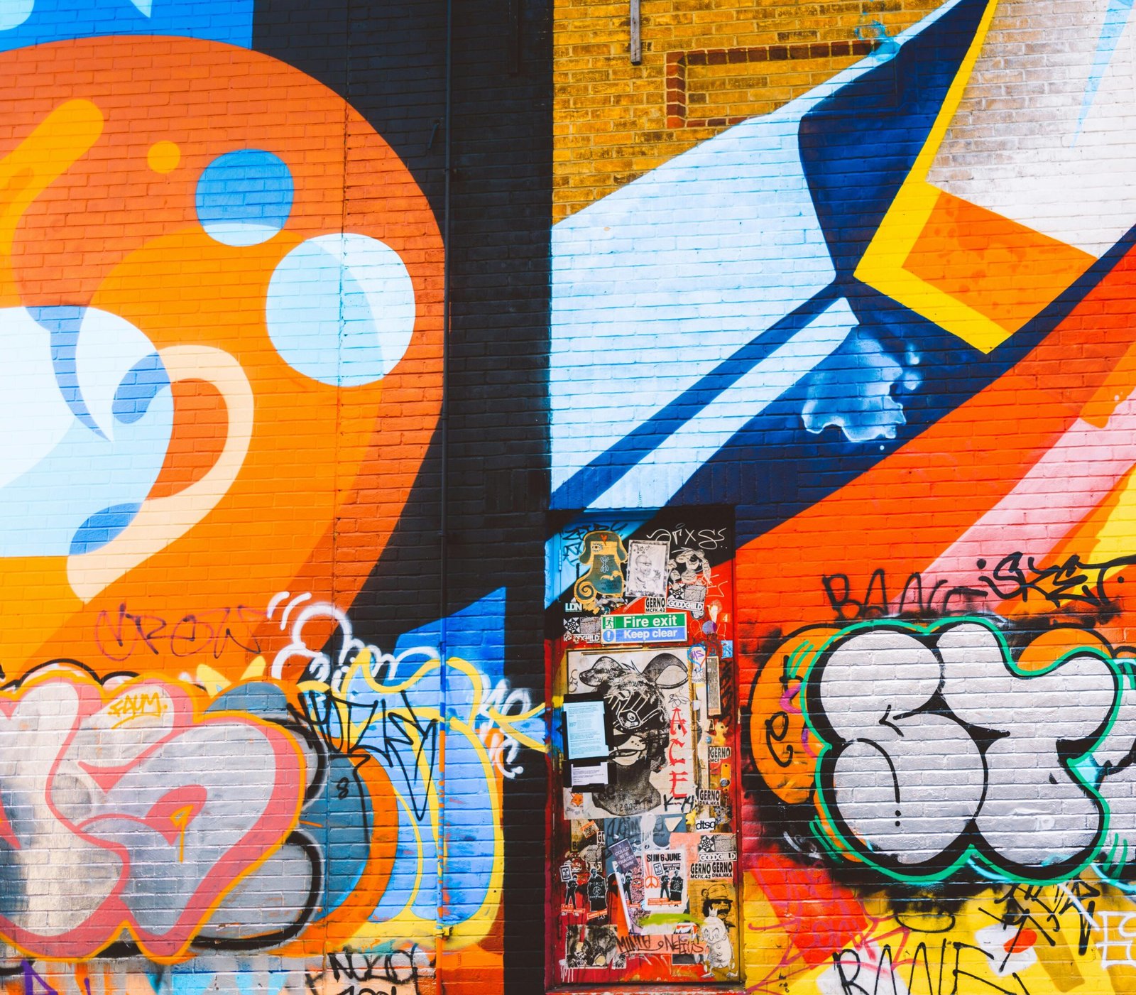 Colorful graffiti mural on a brick wall featuring abstract and bold designs.